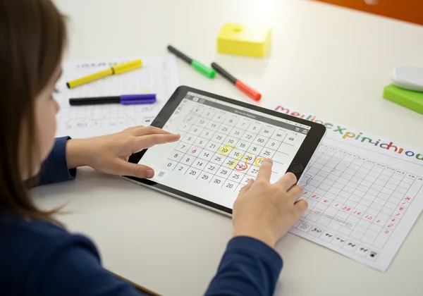 Child using both interactive and printable multiplication charts