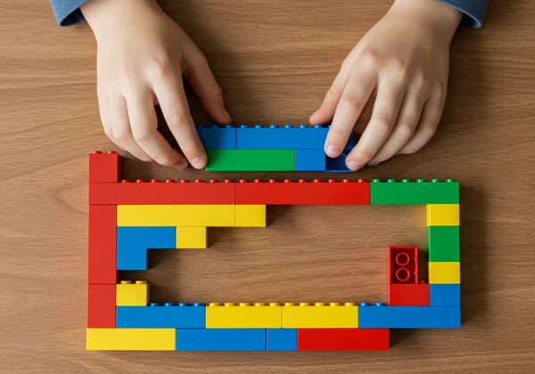Child building a LEGO wall, showing multiplication.